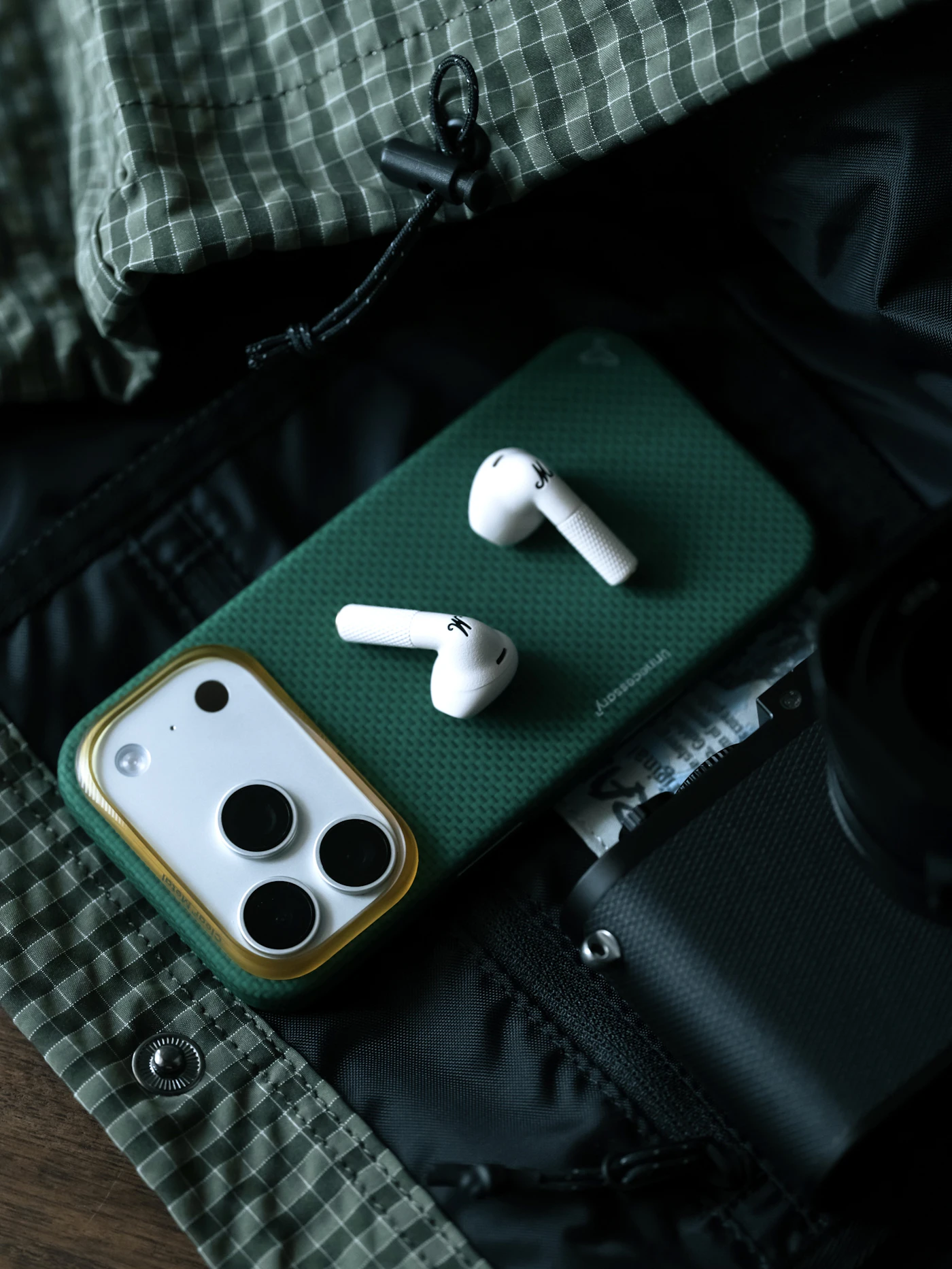 Wireless earbuds rest on a green phone case